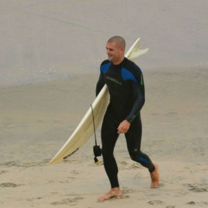 surfer coming out of water surfboard surfing beach blacks beach california layback travel surfsession