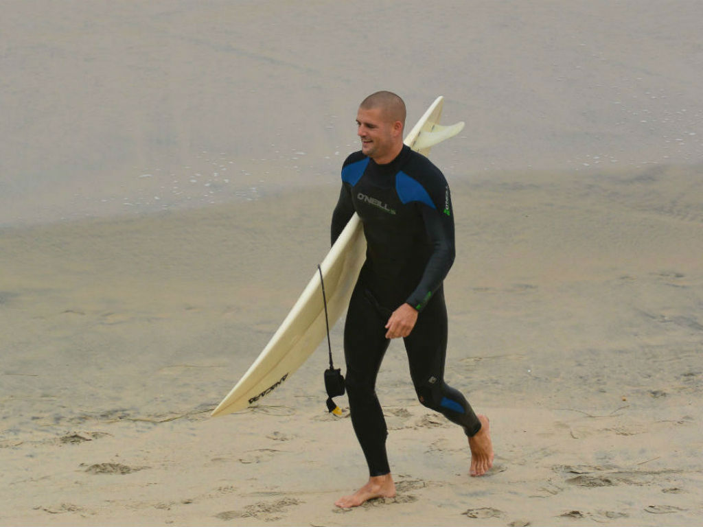 surfer coming out of water surfboard surfing beach blacks beach california layback travel surfsession