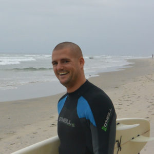 surfer beach carrying surfboard waves ocean blacks beach california layback travel wetsuit