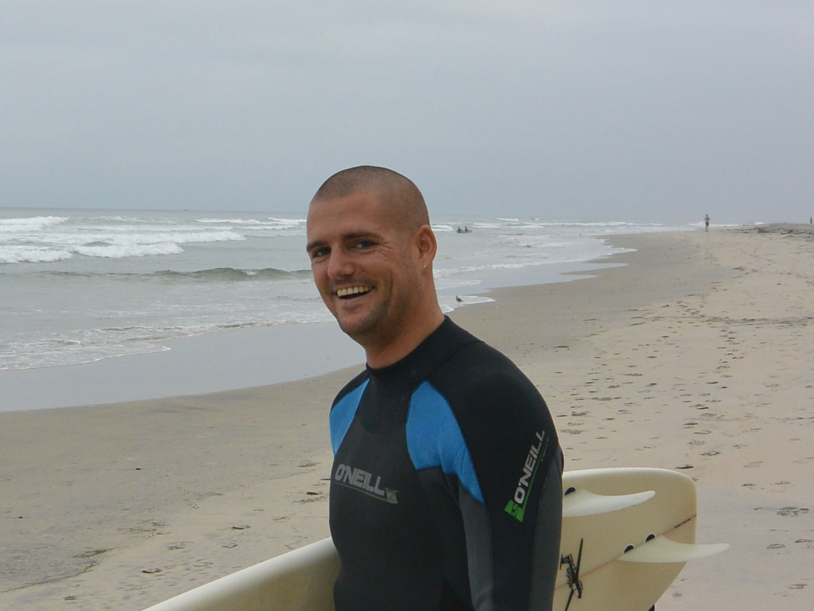 surfer beach carrying surfboard waves ocean blacks beach california layback travel wetsuit